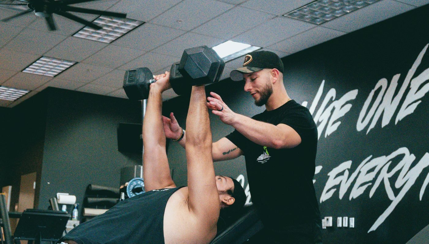 Personal coaching — trainer spotting a bench press